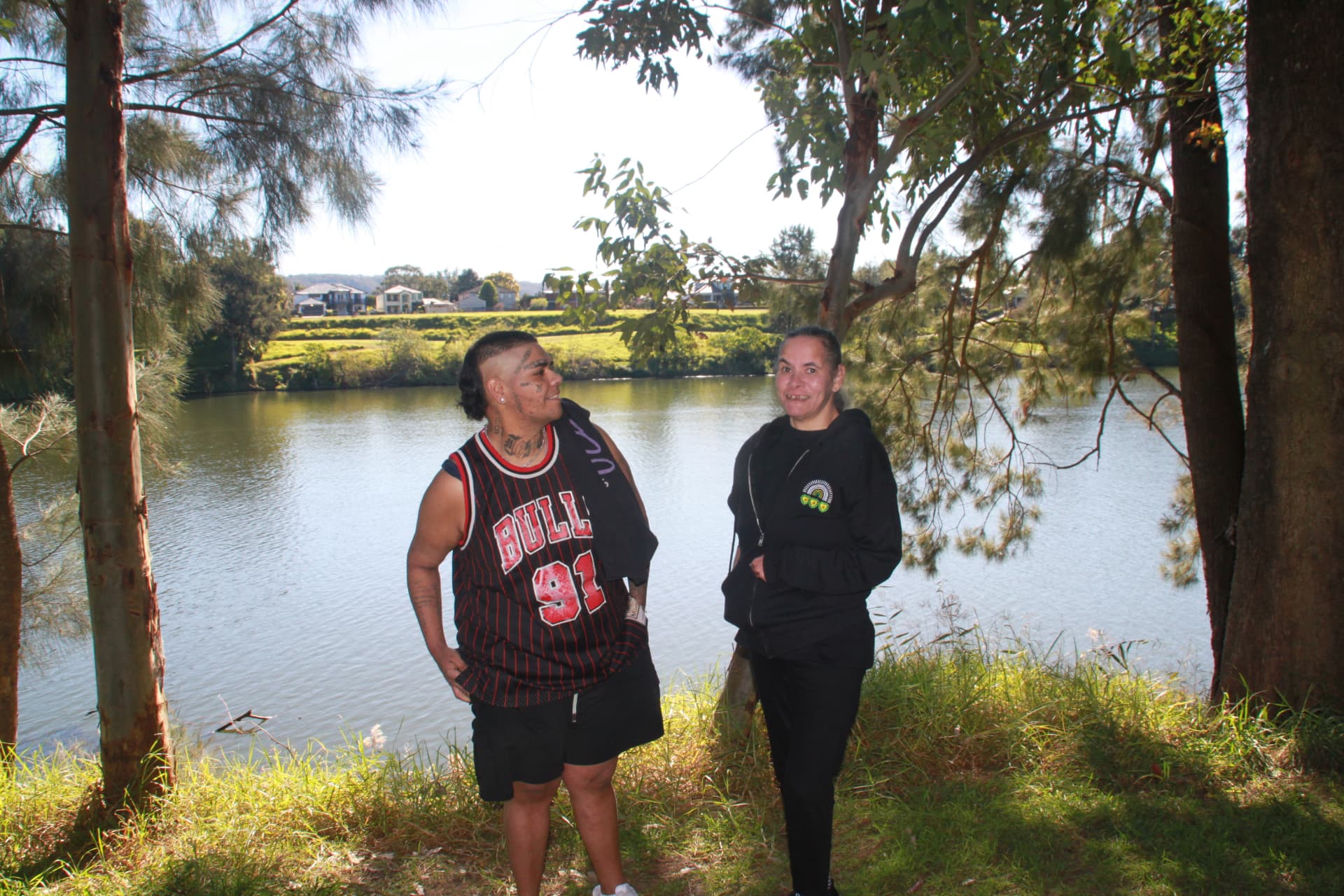 Support coordinator yarning with a participant beside the river